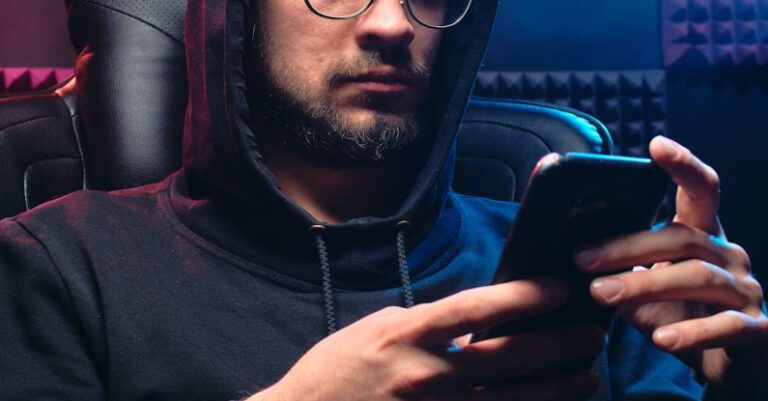 Data Breach Protocols - A Man in Black Hoodie Sweater Using His Mobile Phone